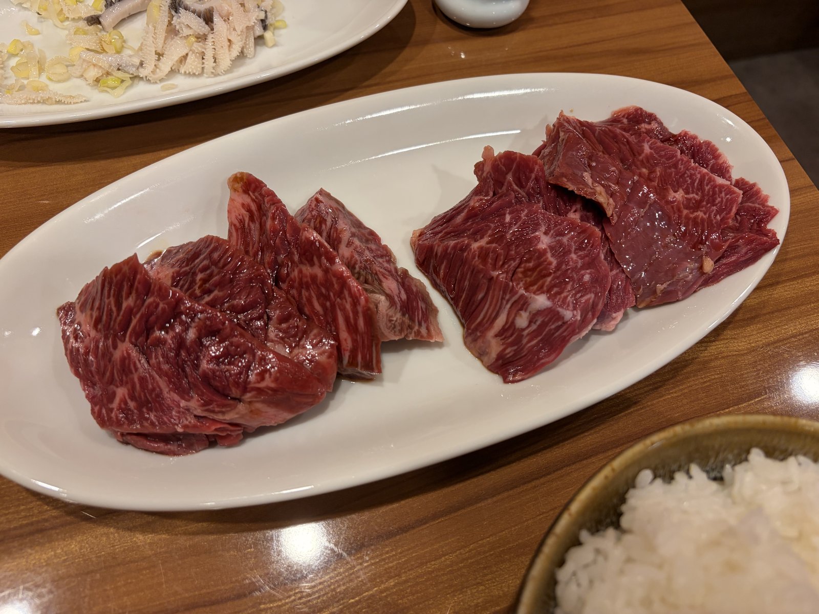 焼肉海雲亭の厚切りの赤身。白い楕円皿の左右に、筋の入り方が違う2種類の赤身が分けて盛られている